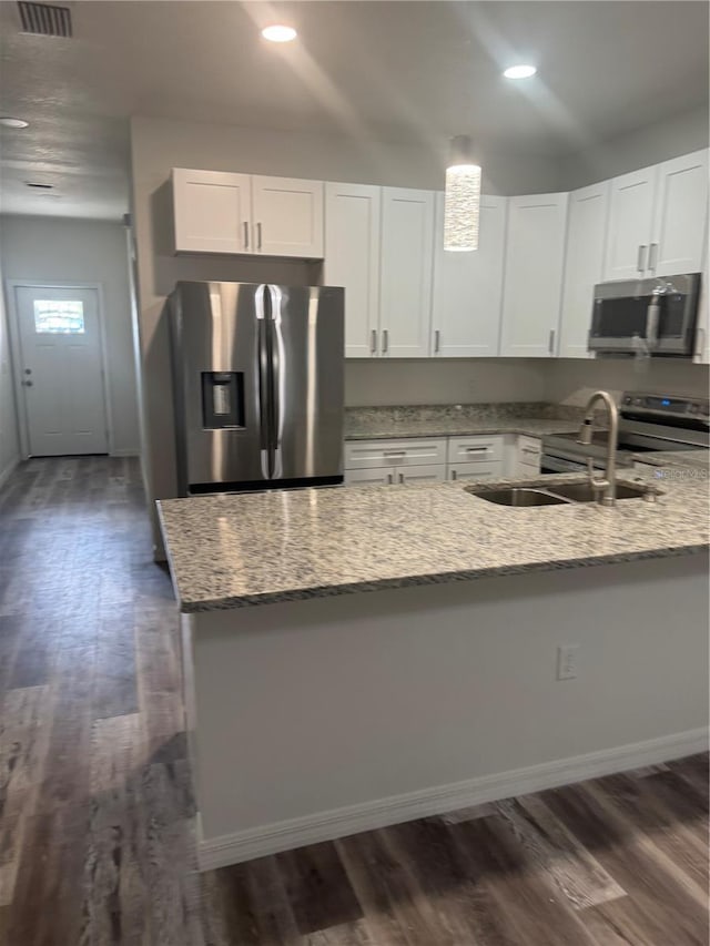 926 Clover St, Deland, FL 32720 - kitchen with dark wood-type flooring, white cabinetry, light stone countertops, and stainless steel appliances