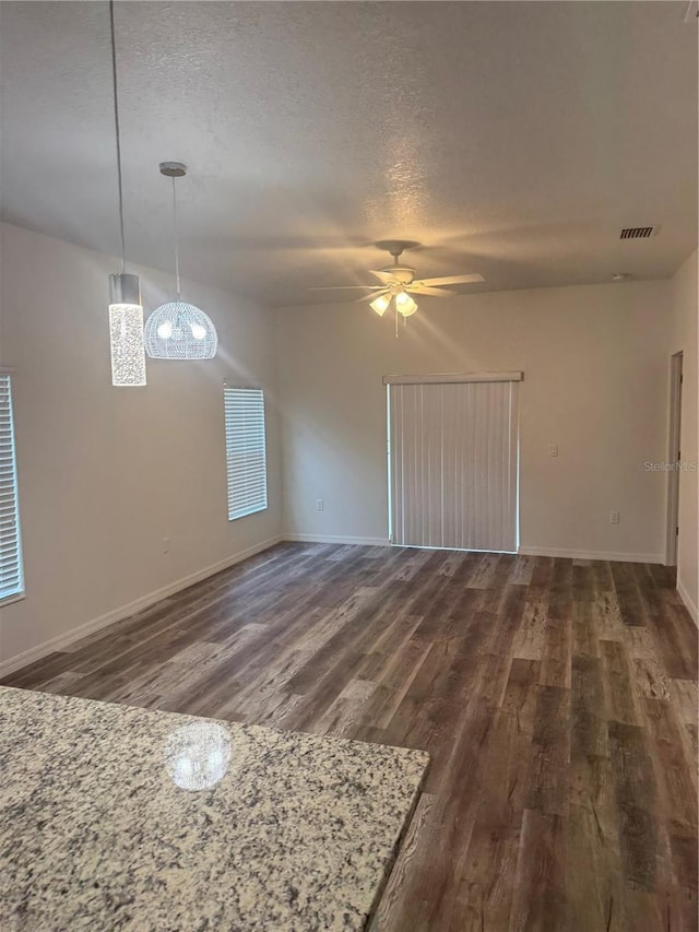 926 Clover St, Deland, FL 32720 - unfurnished living room with ceiling fan, a textured ceiling, baseboards, dark wood-type flooring, and visible vents