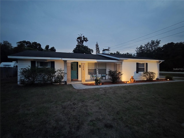 single story home with a porch and a front lawn