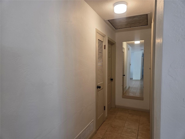 corridor with visible vents and light tile patterned floors