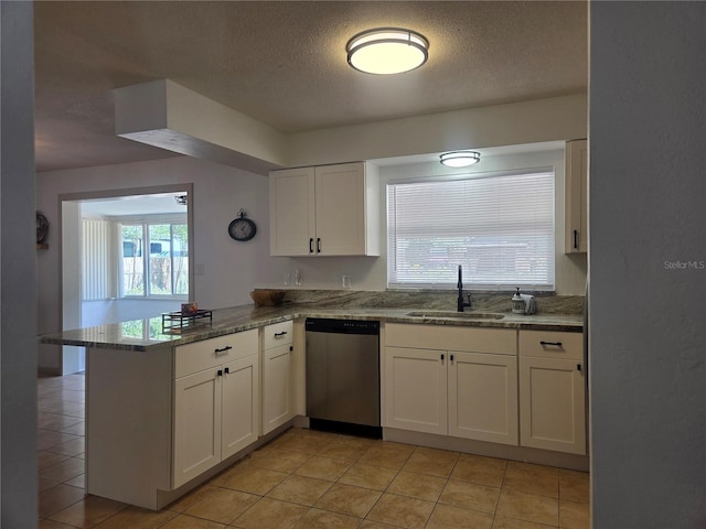 kitchen featuring a sink, dishwasher, a textured ceiling, a peninsula, and white cabinetry
