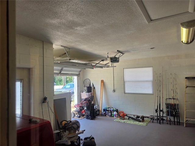 garage featuring concrete block wall and a garage door opener