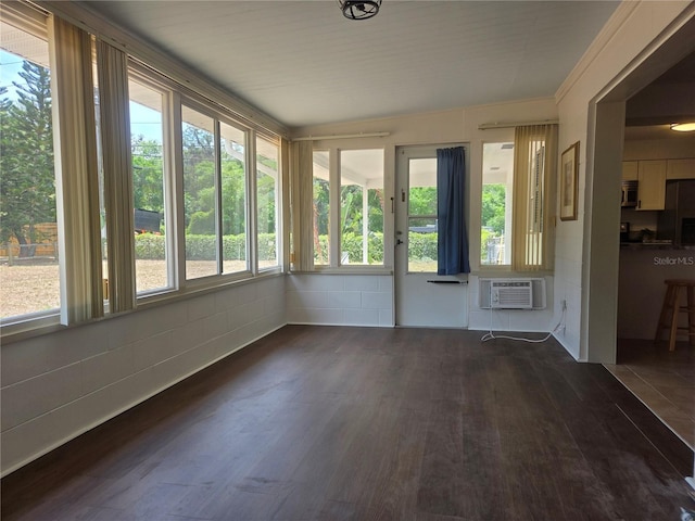 unfurnished sunroom with an AC wall unit and wood finished floors