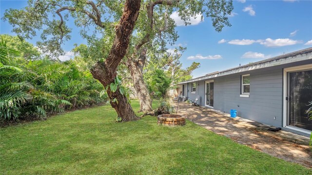 88 Valencia Dr, Ormond Beach, FL 32176 - view of green lawn featuring a fire pit and a patio area