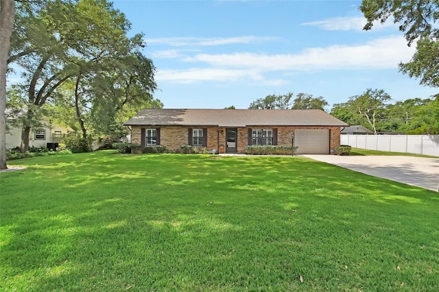 single story home featuring a garage, a front lawn, fence, brick siding, and concrete driveway