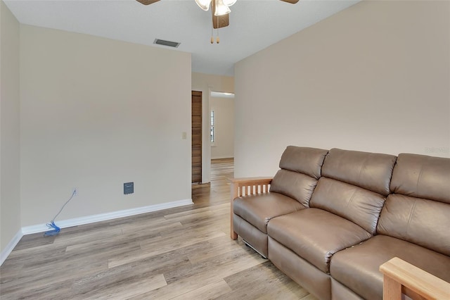 living area featuring a ceiling fan, baseboards, visible vents, and light wood-style flooring