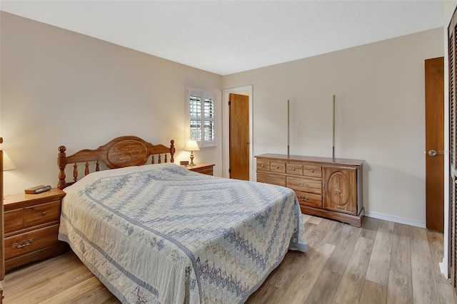 bedroom with baseboards and light wood finished floors