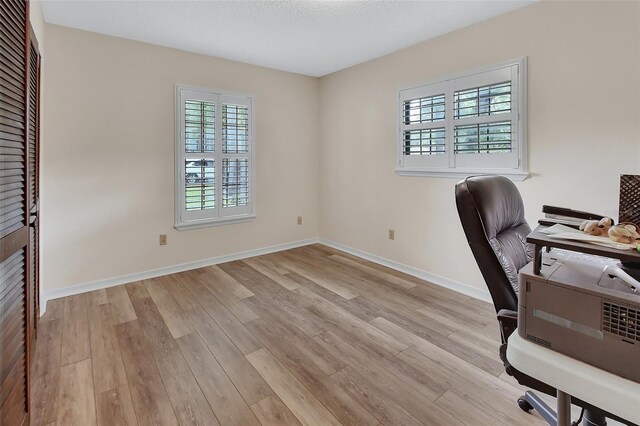 office space featuring light wood-style floors and baseboards