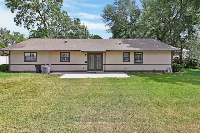 rear view of house with a lawn, a patio area, french doors, and cooling unit