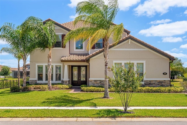 163 Rosa Bella Vw, Debary, FL 32713 - mediterranean / spanish-style home with a front lawn, a tile roof, stone siding, stucco siding, and french doors