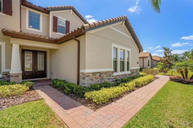 163 Rosa Bella Vw, Debary, FL 32713 - exterior space featuring french doors, a yard, a tile roof, and stone siding