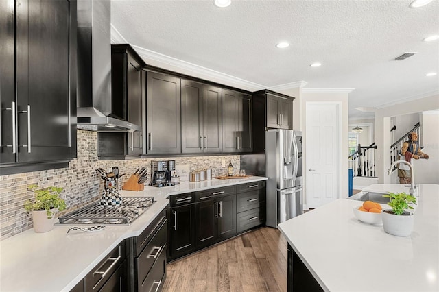163 Rosa Bella Vw, Debary, FL 32713 - kitchen featuring wall chimney range hood, appliances with stainless steel finishes, a sink, light countertops, and ornamental molding
