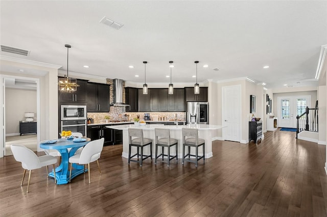 163 Rosa Bella Vw, Debary, FL 32713 - kitchen featuring an island with sink, light countertops, appliances with stainless steel finishes, and wall chimney range hood