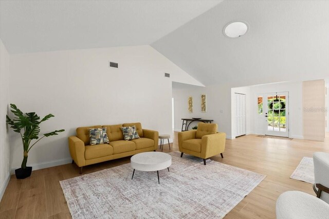 living room with high vaulted ceiling, visible vents, baseboards, and light wood-style floors