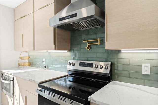 kitchen with stainless steel appliances, light stone countertops, ventilation hood, and tasteful backsplash