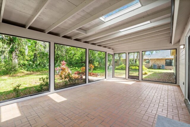 unfurnished sunroom featuring a skylight and beam ceiling