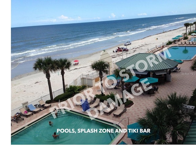 drone / aerial view with a beach view and a water view