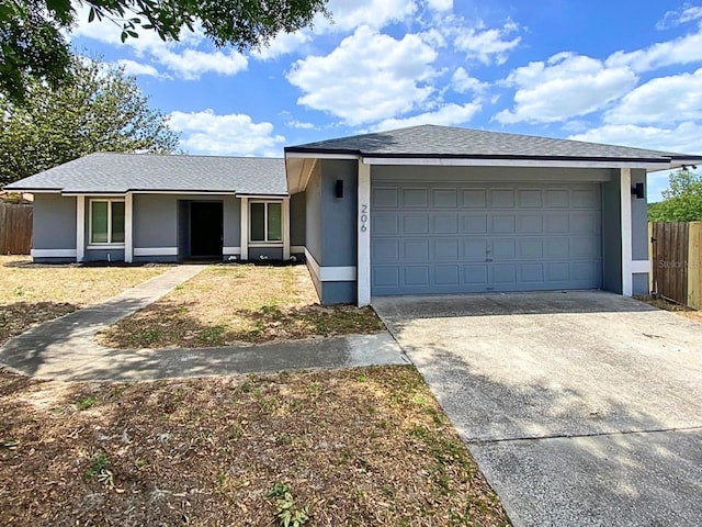 206 Westmoor Bnd, Orlando, FL 32835 - ranch-style house featuring fence, an attached garage, driveway, and stucco siding
