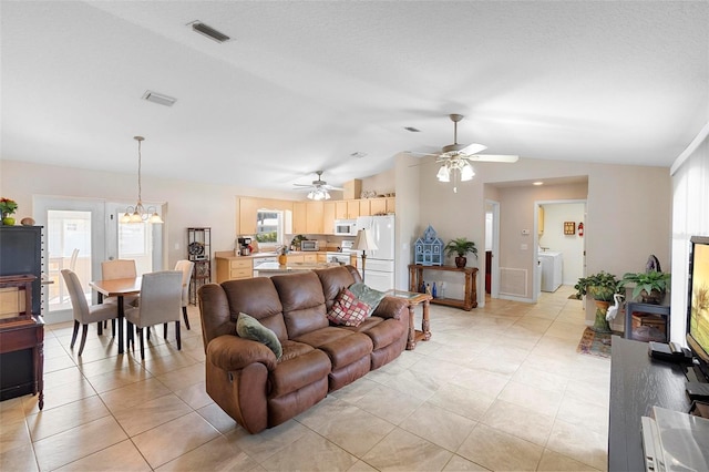 1715 Queen Palm Dr, Edgewater, FL 32132 - living area with lofted ceiling, light tile patterned floors, ceiling fan, washing machine and clothes dryer, and a chandelier