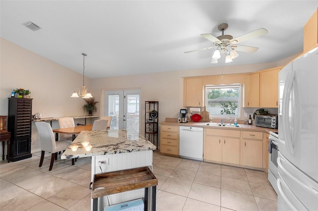 1715 Queen Palm Dr, Edgewater, FL 32132 - kitchen featuring white appliances, light countertops, light brown cabinetry, plenty of natural light, and vaulted ceiling