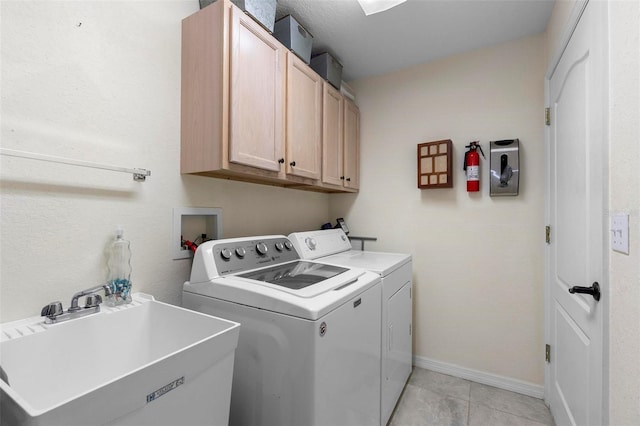 1715 Queen Palm Dr, Edgewater, FL 32132 - washroom featuring cabinet space, washing machine and clothes dryer, light tile patterned floors, and baseboards