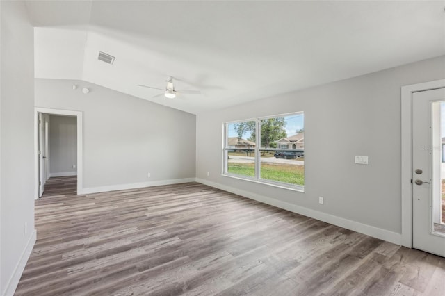 unfurnished living room with lofted ceiling, ceiling fan, visible vents, and wood finished floors