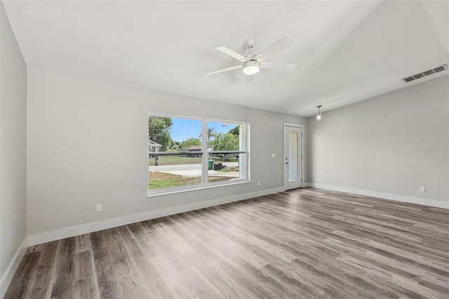 unfurnished room featuring baseboards, a ceiling fan, visible vents, and wood finished floors