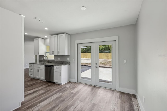 kitchen with french doors, dishwasher, baseboards, white cabinetry, and wood finished floors