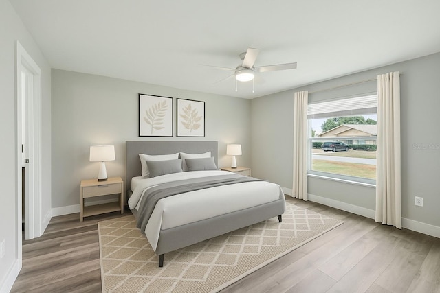 bedroom featuring baseboards, light wood-style floors, and ceiling fan