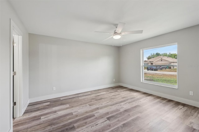 spare room featuring wood finished floors, baseboards, and ceiling fan
