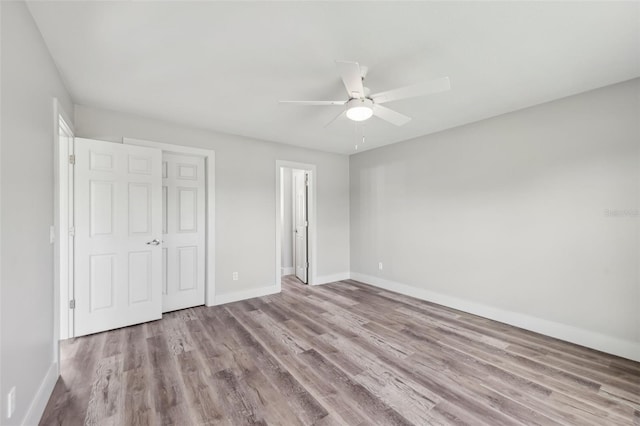 unfurnished bedroom with wood finished floors, baseboards, and ceiling fan