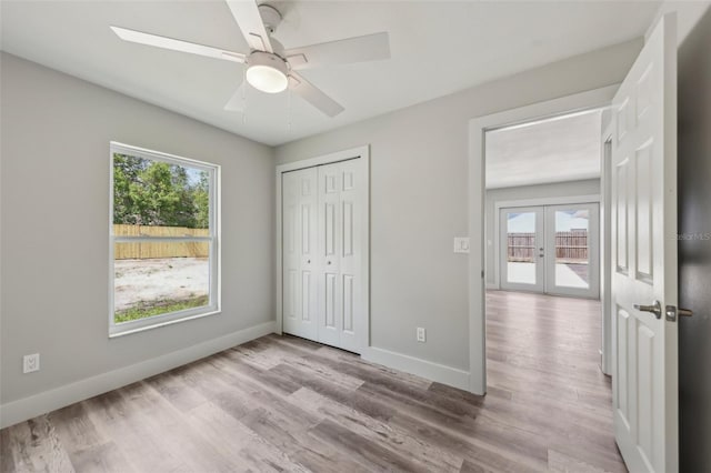 unfurnished bedroom with baseboards, french doors, and wood finished floors