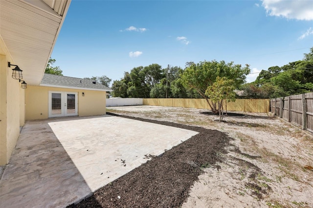 view of yard featuring a patio area, french doors, and a fenced backyard