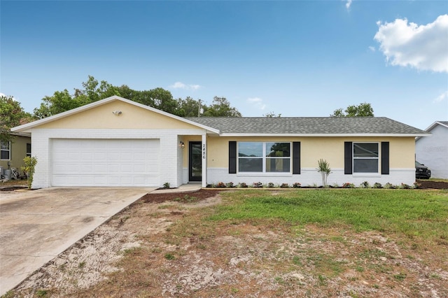 ranch-style home with an attached garage, a front lawn, concrete driveway, a shingled roof, and brick siding