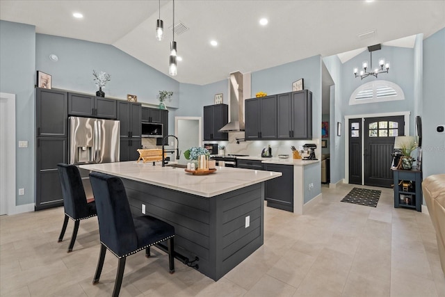 1446 Stone Trl, Enterprise, FL 32725 - kitchen with wall chimney range hood, high vaulted ceiling, visible vents, a center island with sink, and an inviting chandelier