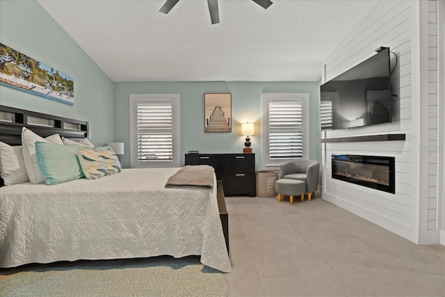 1446 Stone Trl, Enterprise, FL 32725 - bedroom featuring tile patterned floors, a textured ceiling, a fireplace, and ceiling fan