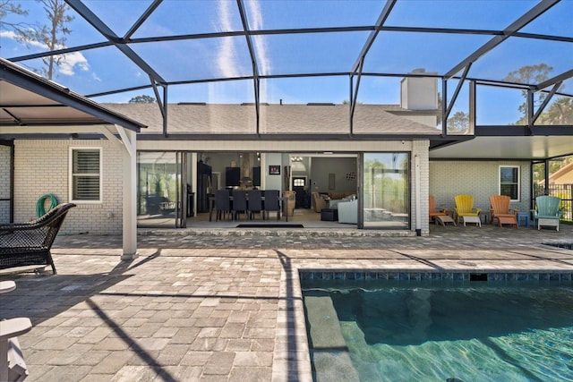 1446 Stone Trl, Enterprise, FL 32725 - rear view of property featuring a chimney, brick siding, a lanai, an outdoor pool, and a patio area