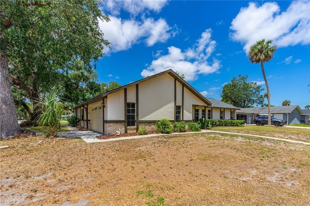 5788 Devon St, Port Orange, FL 32127 - view of front of house with stucco siding, an attached garage, and brick siding
