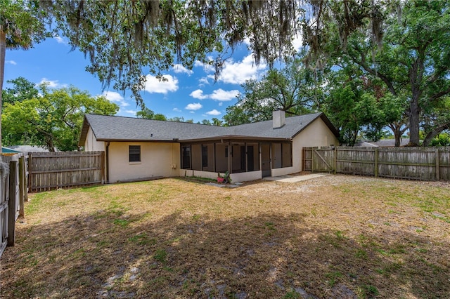 5788 Devon St, Port Orange, FL 32127 - rear view of property with a sunroom, stucco siding, a chimney, and roof with shingles