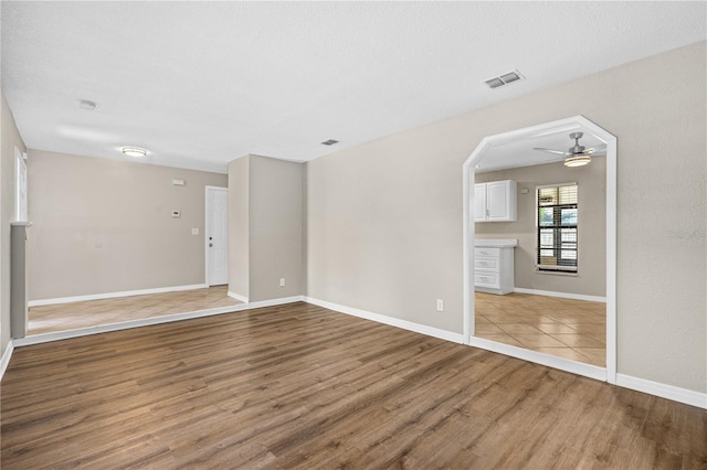 5788 Devon St, Port Orange, FL 32127 - empty room with wood finished floors, ceiling fan, and baseboards