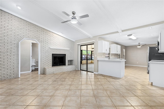 5788 Devon St, Port Orange, FL 32127 - kitchen with ceiling fan, open floor plan, light tile patterned flooring, white cabinets, and brick wall