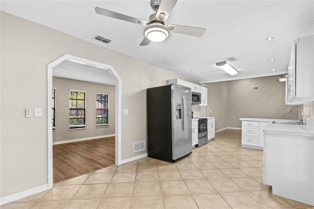 5788 Devon St, Port Orange, FL 32127 - kitchen with stainless steel appliances, a sink, white cabinets, light countertops, and ceiling fan