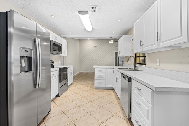 5788 Devon St, Port Orange, FL 32127 - kitchen with appliances with stainless steel finishes, a sink, light countertops, white cabinets, and a textured ceiling