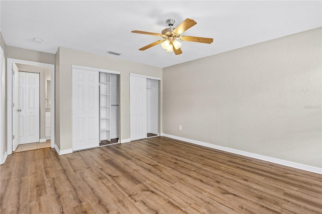 5788 Devon St, Port Orange, FL 32127 - unfurnished bedroom featuring baseboards, wood finished floors, and multiple closets
