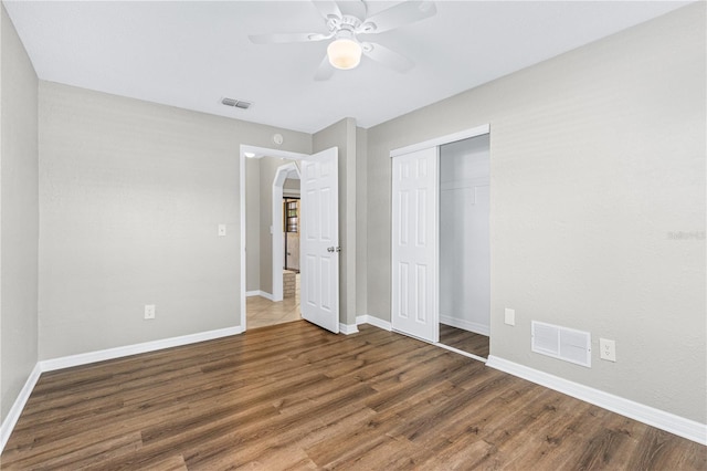 5788 Devon St, Port Orange, FL 32127 - unfurnished bedroom with wood finished floors, baseboards, a closet, and arched walkways