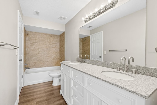5788 Devon St, Port Orange, FL 32127 - bathroom featuring toilet, shower / bathtub combination, wood finished floors, and double vanity