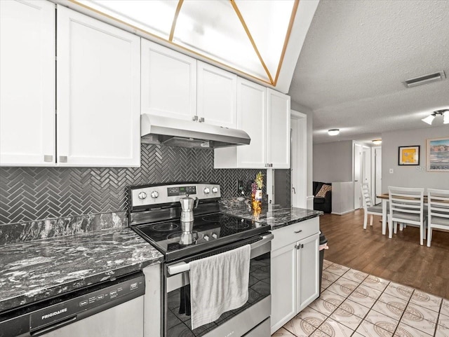 kitchen with visible vents, white cabinetry, under cabinet range hood, backsplash, and stainless steel appliances