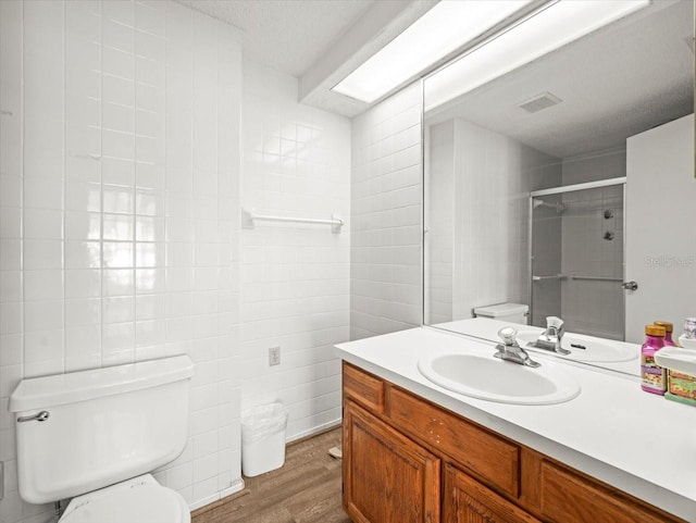 full bathroom with visible vents, a stall shower, wood finished floors, vanity, and toilet