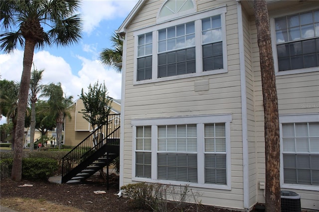 view of side of property with stairs and central air condition unit