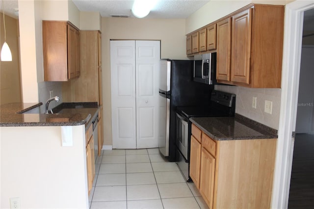 kitchen featuring decorative backsplash, electric range, light tile patterned flooring, stainless steel microwave, and dark stone countertops